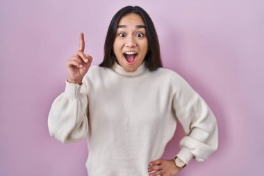 Pembe arka planda duran genç Güney Asyalı kadın başarılı bir fikri işaret ediyor. Heyecanlı ve mutlu. Bir numara.. 