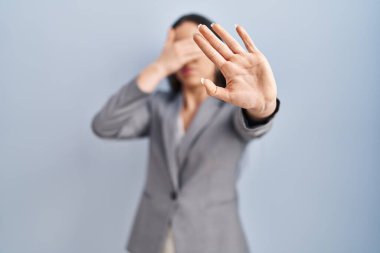 İspanyol iş kadını, gözlük takıyor, gözlerini elleriyle kapatıyor ve üzgün ve korku ifadeleriyle jest yapıyor. utangaç ve olumsuz kavram. 