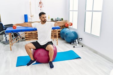 Genç İspanyol hasta rehabilitasyon seansı için klinikteki halterleri ve topları kullanıyor.