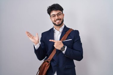 İş kıyafetleri giymiş İspanyol bir adam kameraya hayret ediyor ve gülümsüyor.. 