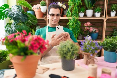 Genç İspanyol çiçekçi çiçekçi çiçekçiye akıllı telefondan fotoğraf dikmiş.