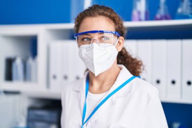 Laboratuvarda tıbbi maske takan güzel İspanyol kadın bilim adamı.