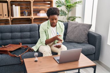 Afrika kökenli Amerikalı kadın psikolog, psikoloji merkezindeki kanepede oturuyor.