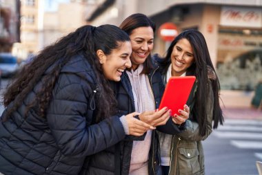 Three woman mother and daughters having video call at street