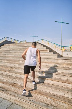 İspanyol sporcu güneşli bir günde dışarı çıkıp spor yapıyor.