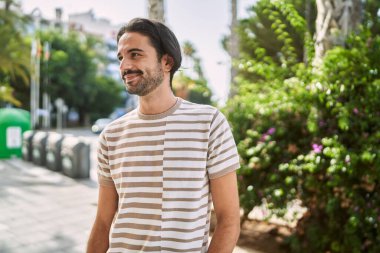 Young hispanic man smiling confident at park