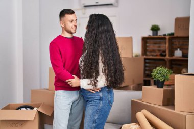 Erkek ve kadın çift yeni evlerinde birbirlerine sarılıyorlar.