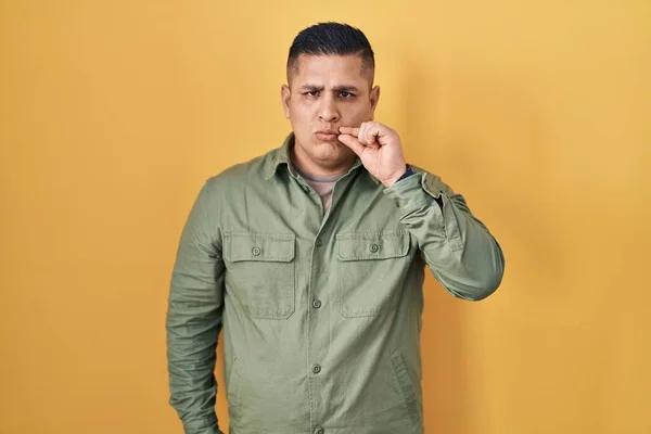Sarı Arka Planda Duran Spanyol Genç Adam Ağzı Dudakları Parmaklarıyla — Stok fotoğraf