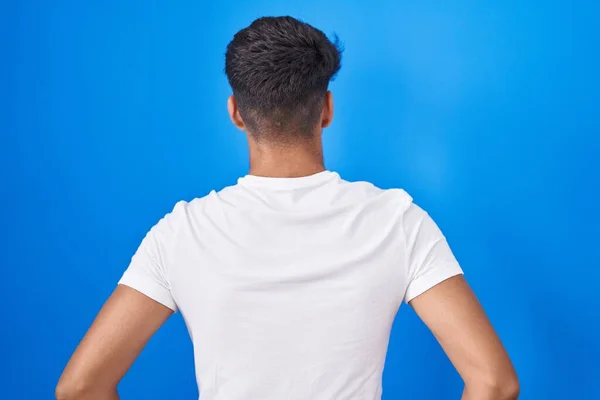 Ισπανόφωνος Έφηβος Στέκεται Πάνω Από Μπλε Φόντο Στέκεται Πίσω Κοιτάζοντας — Φωτογραφία Αρχείου
