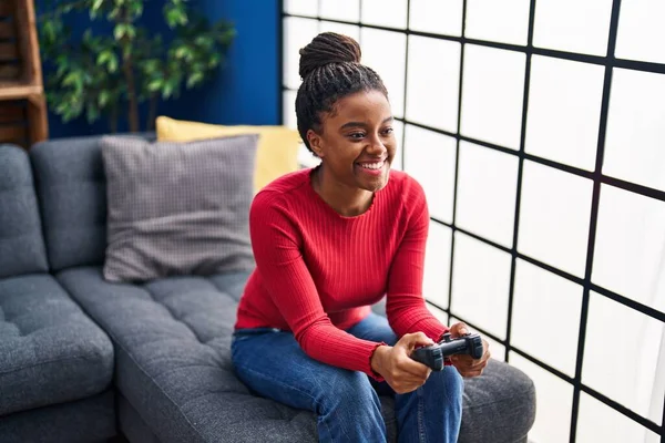 非洲裔美国妇女坐在家里的沙发上玩电子游戏 — 图库照片