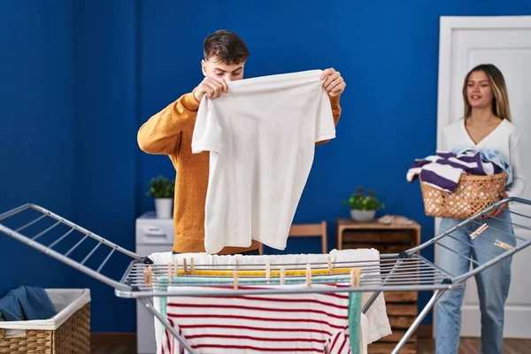 若い男と女カップルハング服上の服で洗濯室 — ストック写真