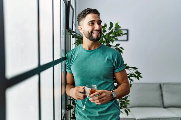 Jovem Árabe Homem Sorrindo Confiante Beber Chá Casa — Fotografia de Stock