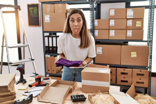 Young Hispanic Woman Working Online Clothe Shop Sticking Tongue Out — Foto de Stock