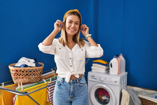 Junge Blonde Frau Der Waschküche Lächelnd Mit Fingern Ohren Zuziehend — Stockfoto