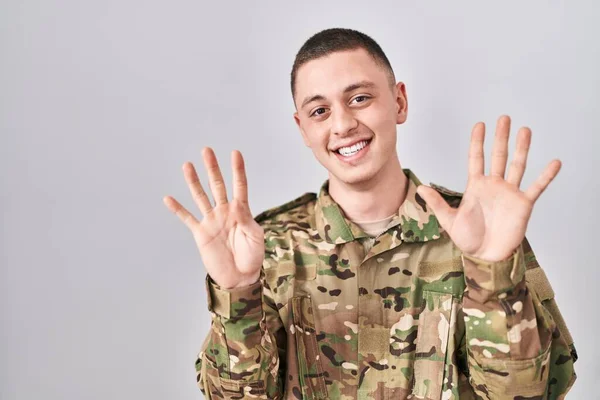 Młody Człowiek Mundurze Wojskowym Pokazujący Wskazujący Palcami Numer Dziewięć Uśmiechnięty — Zdjęcie stockowe