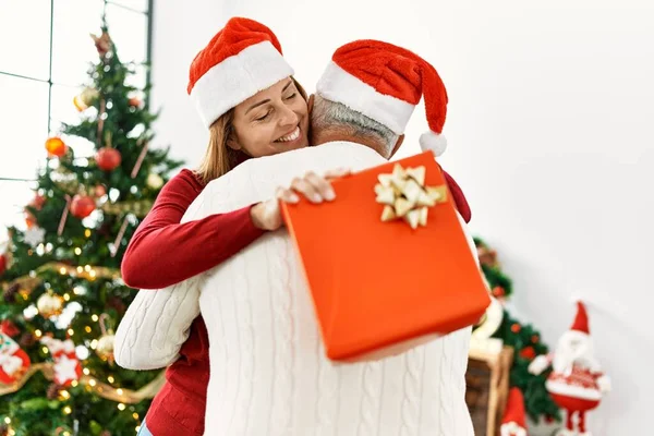 Casal Hispânico Meia Idade Sorrindo Feliz Abraçando Segurando Presente Natal — Fotografia de Stock