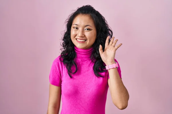 Young Asian Woman Standing Pink Background Waiving Saying Hello Happy — Stockfoto
