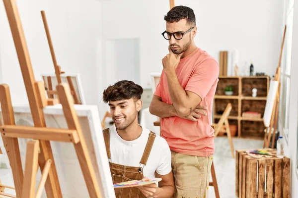 2人のヒスパニック系の男性教師と学生がアートスタジオで描く — ストック写真