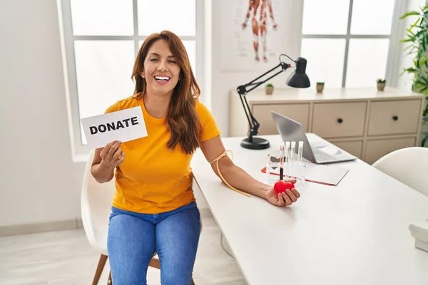 Hispanic woman supporting blood donation smiling and laughing hard out loud because funny crazy joke.