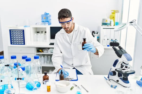 Laboratuvarda bilimsel olarak çalışan yakışıklı İspanyol adam.