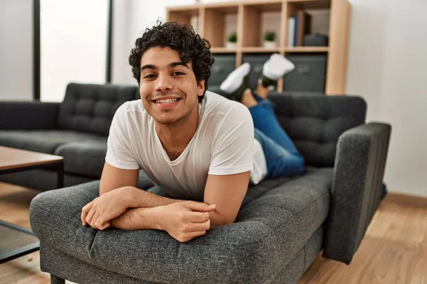 Jovem Hispânico Sorrindo Feliz Deitado Sofá Casa — Fotografia de Stock