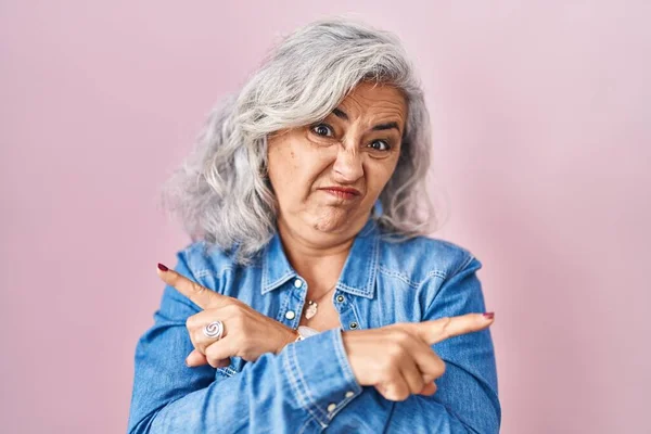 Жінка Середнього Віку Сірим Волоссям Стоїть Над Рожевим Тлом Вказуючи — стокове фото