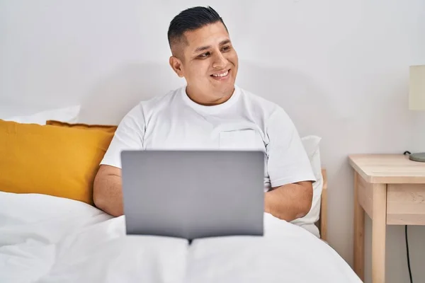 Junger Lateinischer Mann Sitzt Mit Laptop Auf Bett Schlafzimmer — Stockfoto