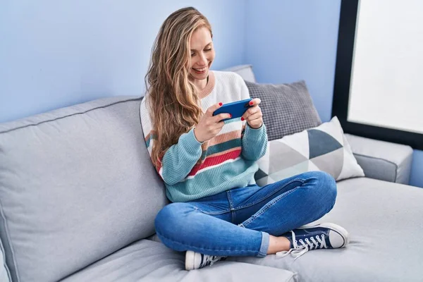 Young Blonde Woman Playing Video Game Sitting Sofa Home — Fotografia de Stock