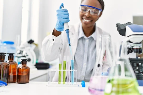 アフリカ系アメリカ人女性科学者が実験室で試験管に液体を注ぐ — ストック写真