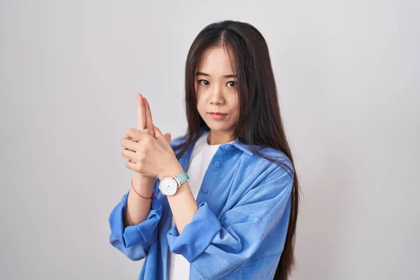 Ung Kinesisk Kvinna Står Över Vit Bakgrund Innehar Symbolisk Pistol — Stockfoto