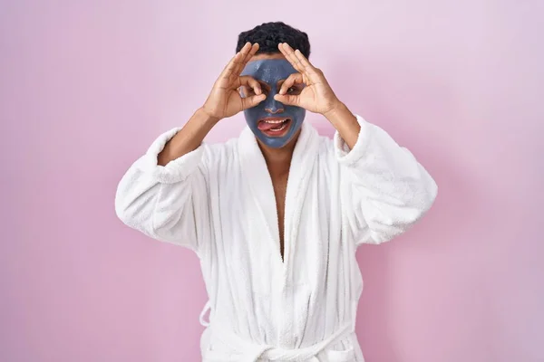 Young Hispanic Man Wearing Beauty Face Mask Bath Robe Doing — Stok fotoğraf