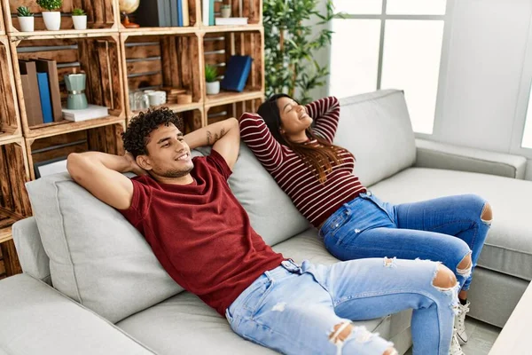 Young Latin Couple Smiling Happy Relaxed Hands Head Sitting Sofa — Stock Photo, Image