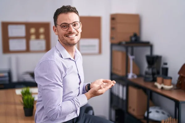 オフィスで若いヒスパニック系の男は脇を指して手を開いてヤシのコピースペースを示し 広告を提示笑顔興奮幸せ — ストック写真