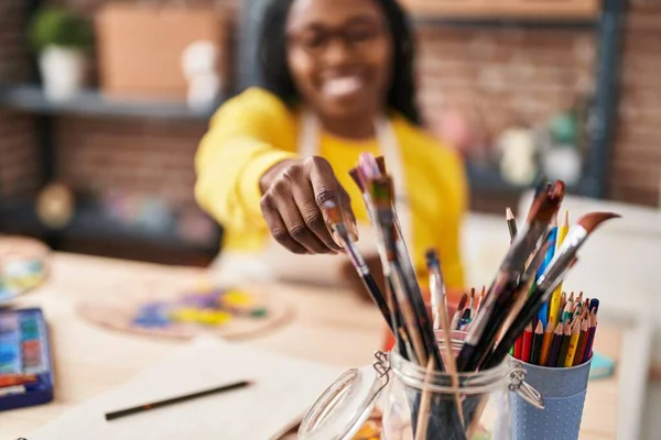 非洲裔美国女艺术家微笑着 自信地在艺术工作室拿着画笔 — 图库照片