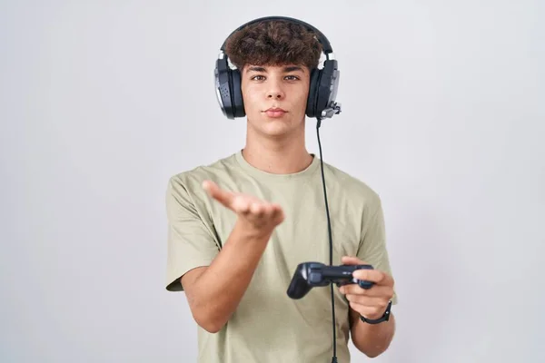 Hispanic Teenager Playing Video Game Holding Controller Looking Camera Blowing — Stock Photo, Image