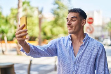 Latin asıllı genç adam gülümsüyor.