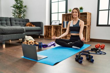 Evde yoga dersi aldığı için kendinden emin gülümseyen genç İspanyol kadın.