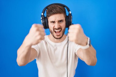 Sakallı, kulaklık takmış öfkeli ve öfkeli bir İspanyol adam öfkeyle bağırırken sinirli yumruklar sallıyor. öfke ve agresif konsept. 