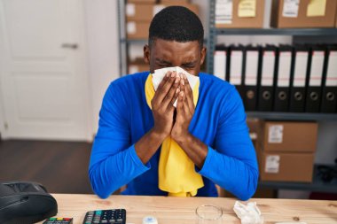 Young african american man ecommerce business worker using napkin at office