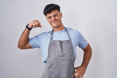 Beyaz arka planda önlük takan İspanyol genç adam yorgun ve rahat, uykulu ve sabahın erken saatlerinde esniyor. 