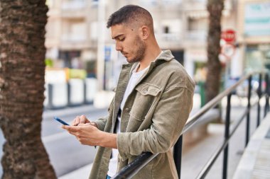 Sokakta akıllı telefon kullanan genç bir İspanyol.