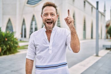 Şehirdeki orta yaşlı adam başarılı bir fikri işaret ediyor. Heyecanlı ve mutlu. Bir numara.. 