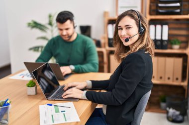Man and woman call center agent using laptop working at office