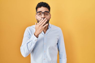 Sarı arka planda duran İspanyol sakallı adam ağzıyla ağzını kapatmaktan sıkılmış. Huzursuz ve uykulu.. 