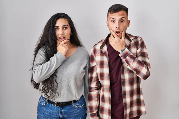 Young Hispanic Couple Standing White Background Looking Fascinated Disbelief Surprise — Stockfoto