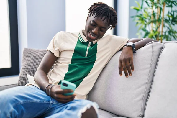 Afričan Američan Pomocí Smartphone Sedí Pohovce Doma — Stock fotografie