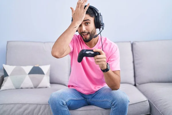Hispánský Mladý Muž Hraje Videohry Drží Ovladač Sedí Pohovce Překvapen — Stock fotografie