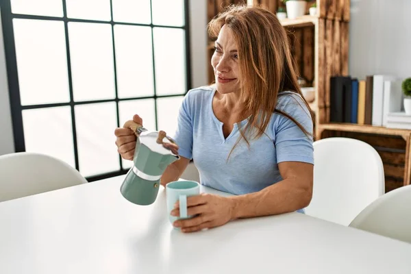 Biała Kobieta Średnim Wieku Pije Kawę Siedząc Stole Domu — Zdjęcie stockowe