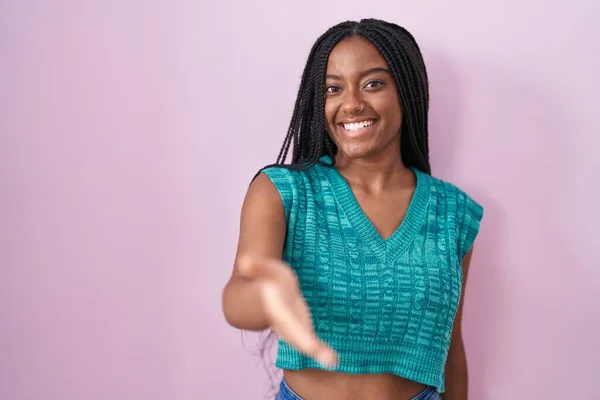 Молодий Афроамериканський Американець Косами Стоять Над Рожевим Тлом Посміхаючись Доброзичливо — стокове фото