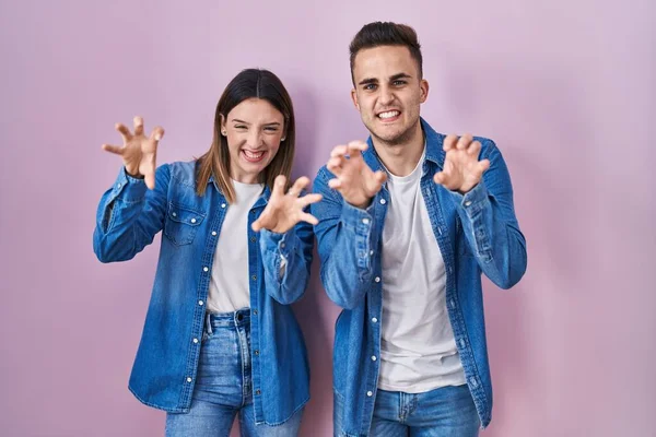 Young Hispanic Couple Standing Pink Background Smiling Funny Doing Claw — Stockfoto